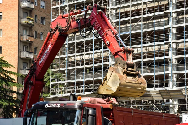 Milan, İtalya - 24 Mayıs 2018: Modern ekskavatör Kazı çalışmaları ve daha aptal kamyon, site bina sanayî Makinaları gerçekleştirir.