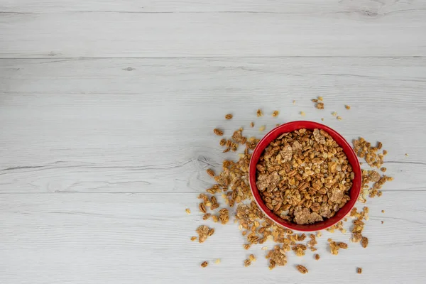 Granola Beyaz ahşap masa, üstten görünüm üzerinde tam kırmızı bir kase