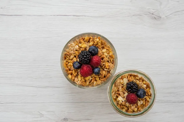 İki kavanoz granola whit çilek Beyaz ahşap masa, üstten görünüm üzerinde tam