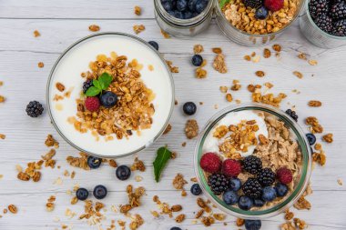 Bowsl yoğurt granola ve üzerinde beyaz ahşap masa, taze çilek ile ana sayfa görünümü