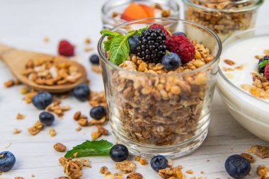 Kavanoz granola, yoğurt ve taze meyveleri ve tahta kaşık tam whit granola, yakın çekim, seçici odak ile tam
