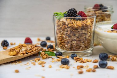 Kavanoz granola, yoğurt ve taze meyveleri ve tahta kaşık tam whit granola, yakın çekim, seçici odak ile tam