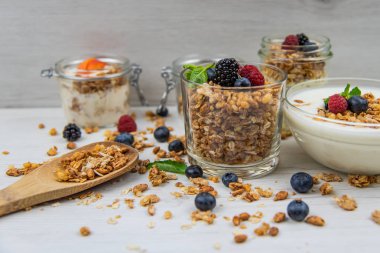 Kavanoz granola, yoğurt ve taze meyveleri ve tahta kaşık tam whit granola, yakın çekim, seçici odak ile tam