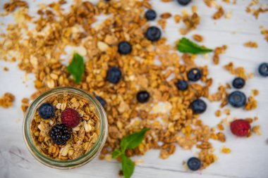 Jar tam granola, yoğurt ve taze meyveler ile yakın çekim, seçici odak, üstten görünüm.