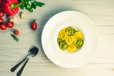 Görünüm Cassic ravioli dolu fesleğen ve bir tabağa Beyaz ahşap bir masa vejetaryen yemek, beyaz peynir ile top.