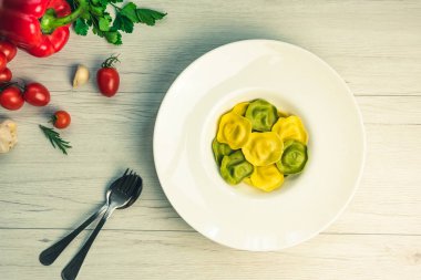 Görünüm Cassic ravioli dolu fesleğen ve bir tabağa Beyaz ahşap bir masa vejetaryen yemek, beyaz peynir ile top.