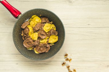 Cassic Mantısı ile dolu fındık ve peynir pişirme tavada, bir beyaz ahşap masa, vejetaryen yemek, üstten görünüm.