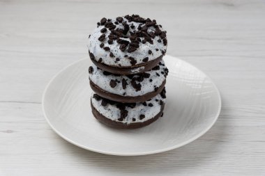 Beyaz ahşap arka planda bir tabakta çörekler, yakın plan.