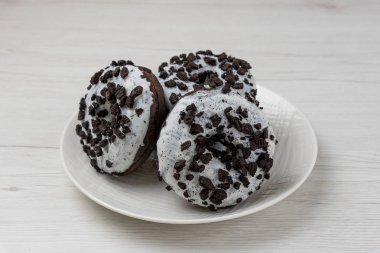 Beyaz ahşap arka planda bir tabakta çörekler, yakın plan.