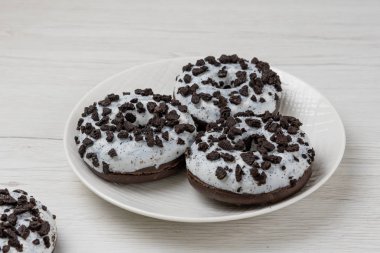 Beyaz ahşap arka planda bir tabakta çörekler, yakın plan.