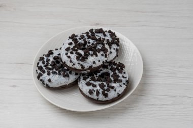 Beyaz ahşap arka planda bir tabakta çörekler, yakın plan.