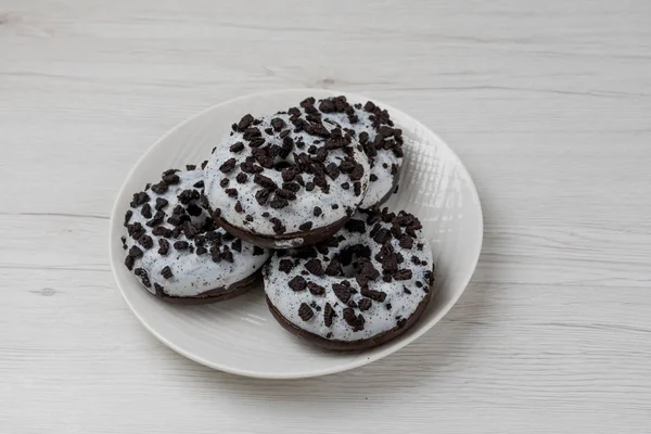 Beyaz ahşap arka planda bir tabakta çörekler, yakın plan.