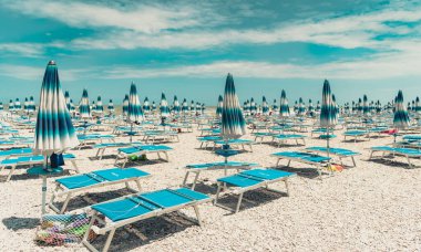 İtalyan Adriyatik Denizi 'nde güneşli yataklı ve şemsiyeli plaj, İtalya.