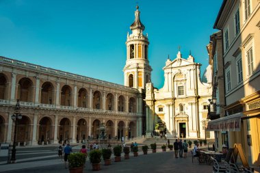 Loreto, İtalya - 10 Temmuz 2020: Loreto ana meydanında Piazza della Madonna adlı turistler duruyor. Maggiore çeşmesinin yanında oturup Kutsal Ev Tapınağı 'nı ziyaret ediyorlar..