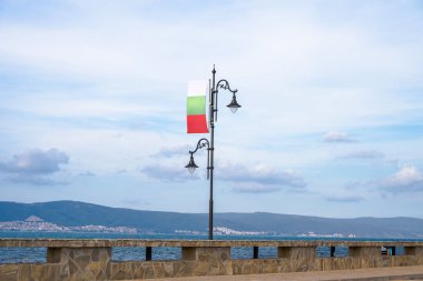 Bir Bulgar bayrağı, açık ve ince bir gökyüzünün altındaki süslü bir sokak lambasına gururla asıldı.