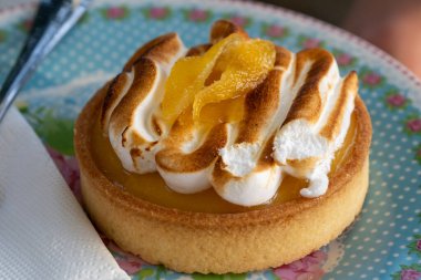 Çok güzel kızartılmış limonlu turta çiçekli bir tabakta oturur, üzerine şeker konmuş ve keyiflenmeye hazır.