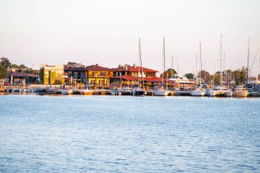  Yelkenliler, Bulgaristan 'ın Nesebar kentindeki sıcak akşam ışığı altında sakin sularda parıldayan, ağaçlarla kaplı bir marinada huzur içinde rıhtıma yanaştılar.