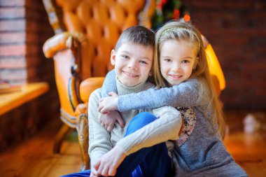 Kız kardeşi yavaşça kayıyor, birlikte gülümsüyor.