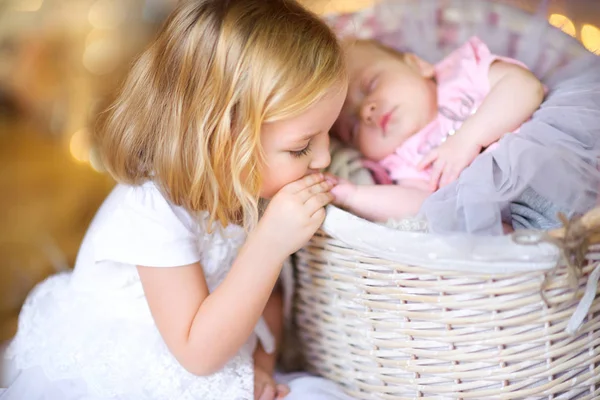 Beautiful Little Girl Kisses Handle Her Newborn Sister Lying Basket — Stock Photo, Image