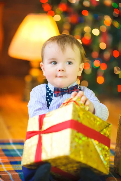 Смешной Ребенок Сидит Полу Большим Подарком Руке Фоне Праздничной Елки — стоковое фото