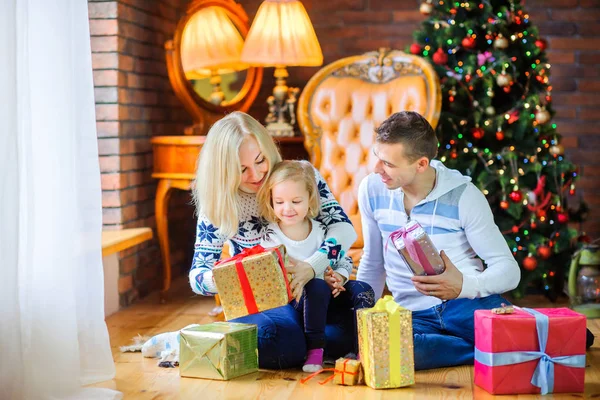 クリスマス ツリーの近くの床の上に座って家族を幸せを祝福を与える互いのプレゼント クリスマスの朝 — ストック写真