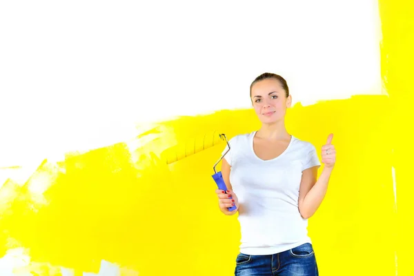 女性画家の壁を塗るために立っているローラー手に笑みを浮かべて クラスを示すと — ストック写真