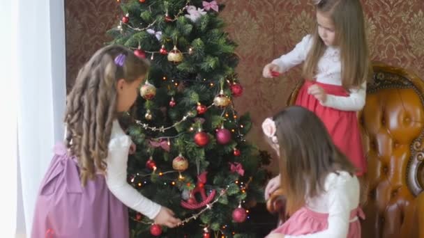 Drei Schöne Mädchen Kleidern Schmücken Einen Weihnachtsbaum Mit Luftballons Vorbereitung — Stockvideo