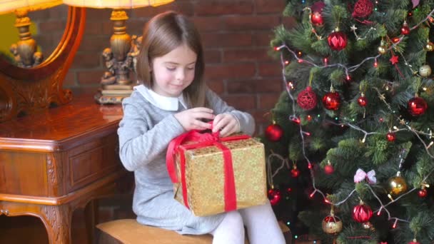 Bambina Seduta Vicino Albero Natale Apre Una Confezione Regalo Carta — Video Stock