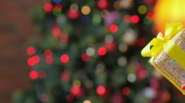Anne kızı, bir Noel ağacı arka plan üzerinde bir hediye verir