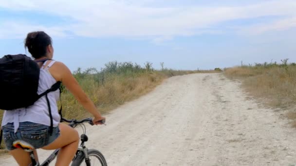 Giovane Ragazza Bicicletta Con Uno Zaino Viaggia Attraverso Campagna — Video Stock