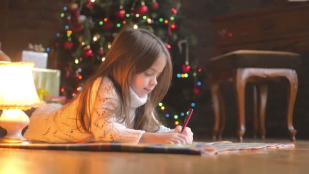 Bambina Sdraiata Sul Pavimento Scrivere Una Lettera Babbo Natale — Video Stock