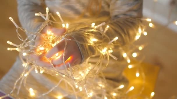 Feriados Close Mãos Uma Menina Segurar Guirlanda Brilhante Luz Quente — Vídeo de Stock