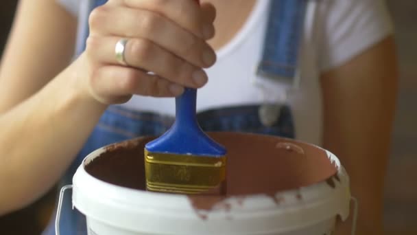 Nahaufnahme, ein Mädchen professionelle Malerin mokay und zeigt Pinsel mit brauner Farbe