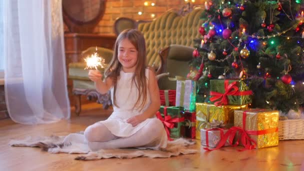 Menina Engraçada Sentada Perto Árvore Natal Brinca Com Faíscas Divertindo — Vídeo de Stock