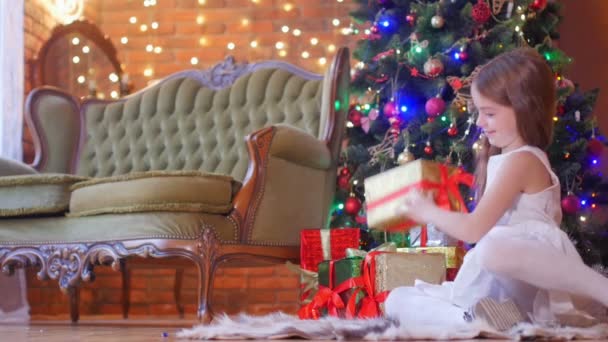 Uma Menina Bonita Vestido Branco Sentado Chão Perto Árvore Natal — Vídeo de Stock