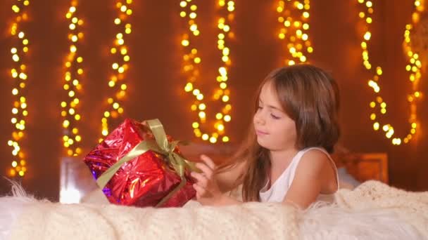 Des Vacances Belle Fille Détache Ruban Ouvre Cadeau Couché Sur — Video