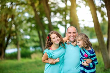 parkta iki kızı ile baba, sarılma ve oyun