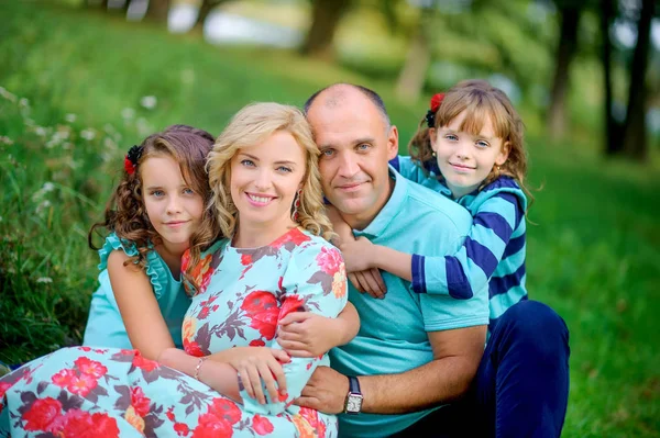 Familia Feliz Descansando Naturaleza Sentada Hierba Abrazando Riendo — Foto de Stock