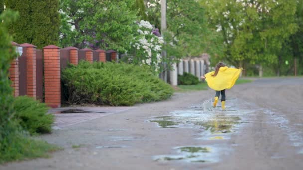 Маленька Мила Дівчина Жовтому Дощовику Чоботи Веселяться Біжить Калюжах Дорозі — стокове відео