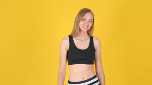 Spor Giyim Deki Mutlu Çekici Kız Gülümseyip Başparmağını Sallıyor Sarı — Stok video
