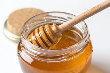 honey with stick on white background