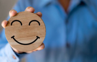 Elinizde odun sembolü gülümseme, bakım, mutluluk, rahatlama, memnuniyet anketi, müşteri hizmetleri, olumlu, iyi, sağlık, çocuk, hastane, dünya akıl sağlığı günü konsepti