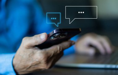 Akıllı telefon yazarak canlı sohbet ve sosyal ağ kavramları kullanarak insan eli, sohbet kutusu ikonlarında çalışan sohbet konuşmaları. Sosyal medya pazarlama teknolojisi kavramı