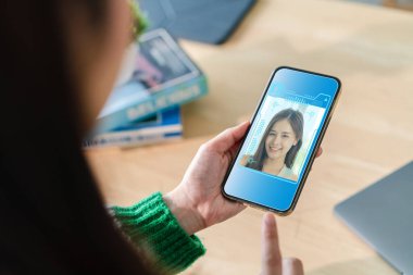 Yüz tanıma teknolojisi iş başında, kullanıcı akıllı telefon, siber güvenlik tutuyor, ekranda yüz tarama arayüzü, kimlik doğrulama için güvenlik sistemleri, erişim kontrolü ve kişiselleştirilmiş 