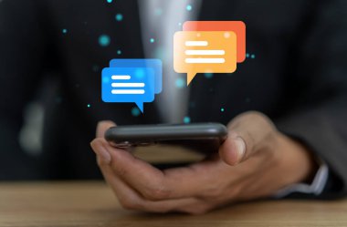 Akıllı telefon yazarak canlı sohbet ve sosyal ağ kavramları kullanarak insan eli, sohbet kutusu ikonlarında çalışan sohbet konuşmaları. Sosyal medya pazarlama teknolojisi kavramı