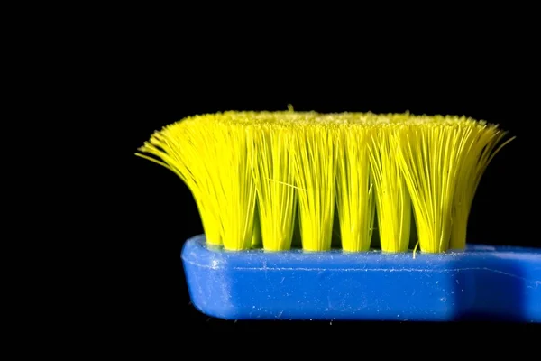 蓝色和黄色使用专业软牙刷与大量的刷毛在直接裁减在黑色背景 — 图库照片