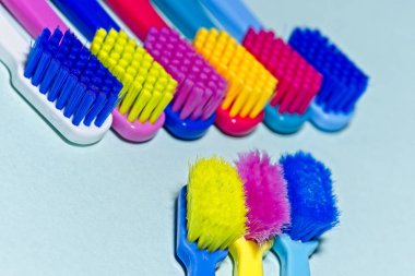 Kullanılan ve yeni renkli profesyonel yumuşak diş fırçası ile kıllar oppositing satırlarındaki ışık üzerinde düz kesim içinde çok arka plan mavi.