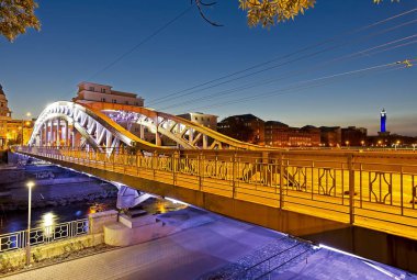 Mavi saat Ostrava Şehir Belediye Binası Saat Kulesi arka planda ile akşam köprü acros nehir Ostravice LED ışık yaktı