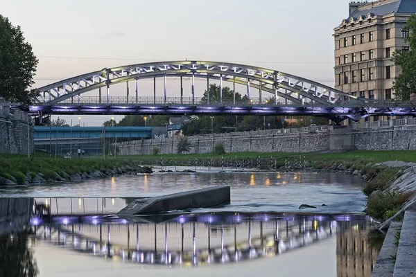 LED light lit bridge acros river Ostravice with it\'s reflection in evening blue hour Ostrava city.