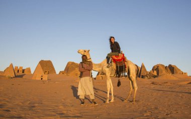 Meroe piramitleri, Sudan 19 Aralık 2015: bir deve piramitleri bir çölde önünde yerel bir adamla bir kadın